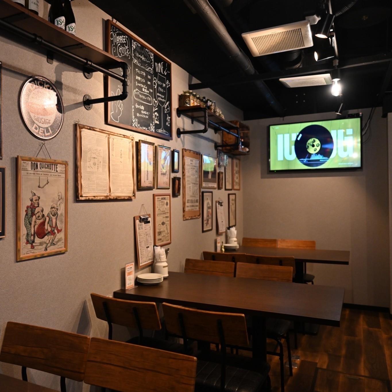 写真が飾られた壁とテーブル席のある店内